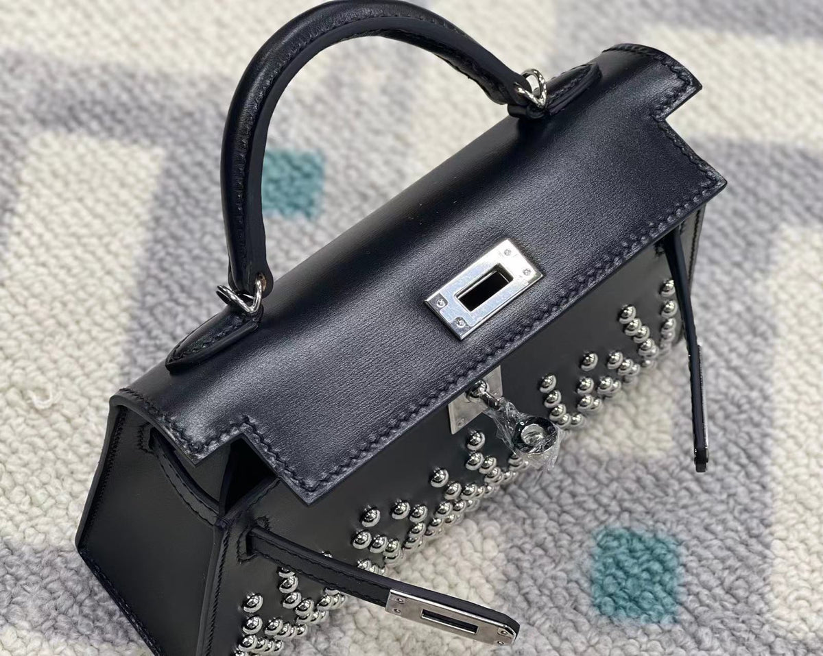 Mini bolso de piel con tachuelas de paladio