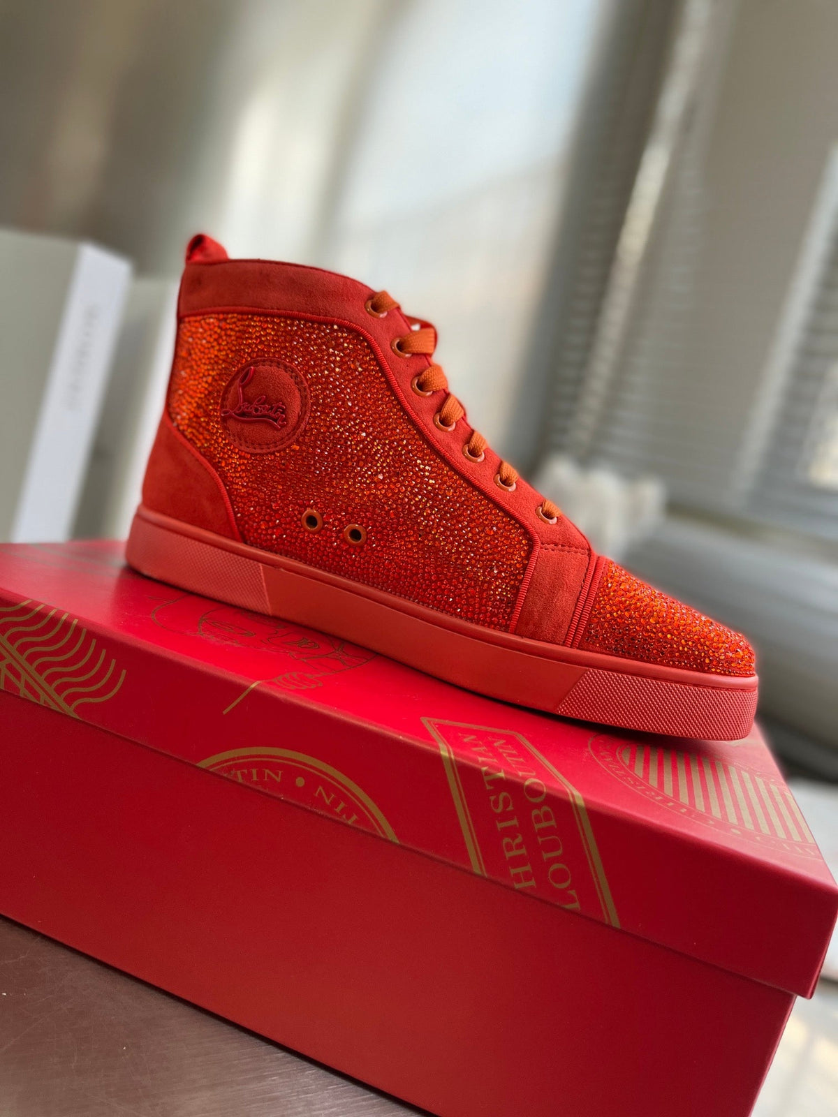 Botas altas naranjas con letras y tachuelas de diamantes