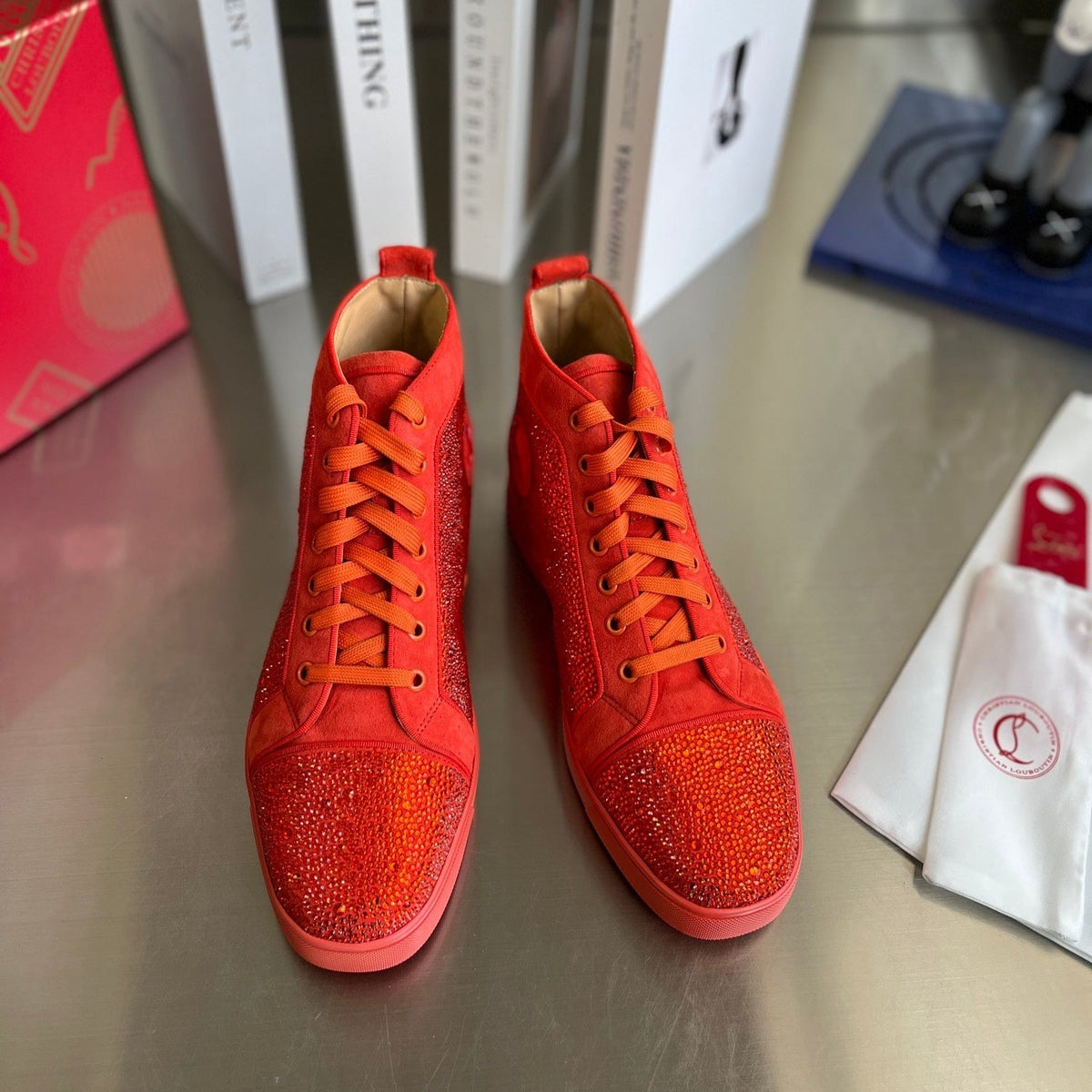 Botas altas naranjas con letras y tachuelas de diamantes